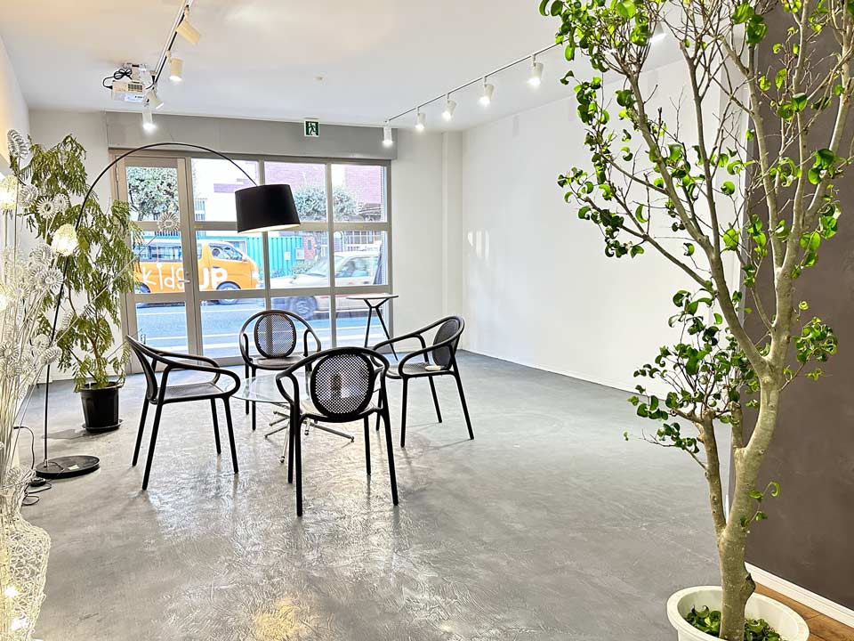 OTSUNAGIドットコムで利用するスペースの風景。グレーを貴重とした高級感のあるスペースの中で椅子が4つローテーブルを囲むように並んでいる。