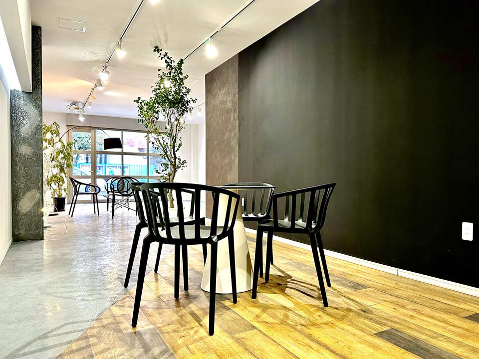 OTSUNAGIドットコムで利用するスペースの風景。木目の床にテーブルと椅子が並んでいる様子。